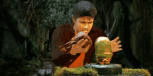 a man is holding a cloth in front of a statue