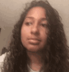 a girl with curly hair is making a funny face .