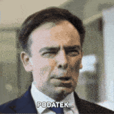 a man in a suit and tie is making a funny face and says " podatk "