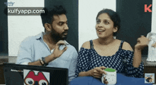 a man and a woman are sitting next to each other and talking .