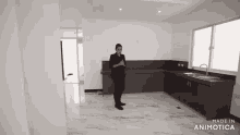 a woman is standing in an empty kitchen with the words made in animotica on the bottom