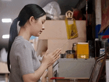 a woman in a ponytail prays in front of a yellow bag that says ' a ' on it