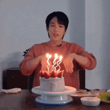 a man is lighting candles on a birthday cake with strawberries on it .