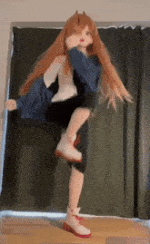 a doll with long red hair is dancing in front of a curtain