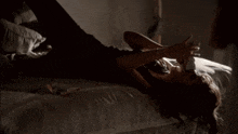 a woman is laying on a bed with her arms outstretched in a dark room