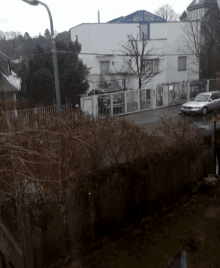 a white car is parked in front of a building that has a sign that says ' polizei ' on it