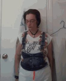 a woman wearing overalls and a t-shirt that says yaw