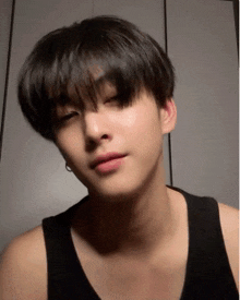a close up of a person 's face with a black tank top on