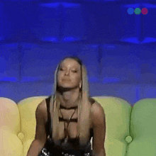 a woman is sitting on a colorful couch and making a face