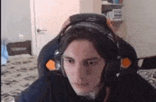 a man wearing headphones is sitting in a chair in a bedroom .
