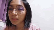 a close up of a woman wearing glasses making a funny face .