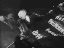 a black and white photo of a man holding a flag that says ' a ' on it