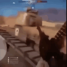 a person is holding a gun in a video game while a tank is in the background .