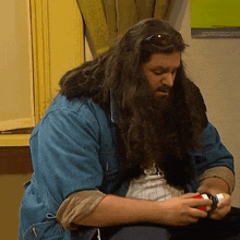 a man with long hair and a beard is holding a bottle of medicine