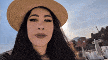 a woman wearing a straw hat is looking at the camera