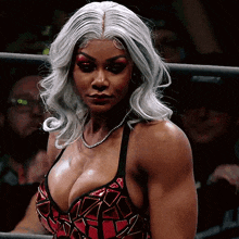 a woman with a very large breast is wearing a red and black outfit