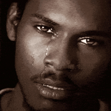 a close up of a man 's face with tears coming out of his eyes