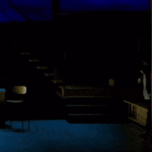 a person walking in a dark room with blue lights