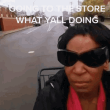 a woman wearing sunglasses is going to the store what y all doing