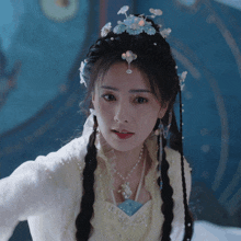 a woman wearing a white dress with pearls and a necklace