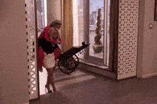 a woman carrying another woman in a wheelchair