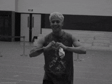 a black and white photo of a man wearing a tank top that says metallica