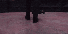 a person 's feet are shown on a pink floor