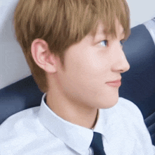 a close up of a person 's face with a white shirt and tie on