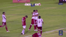 a group of soccer players are hugging on a field with a live fc logo on the bottom