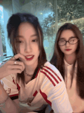 a girl wearing a white shirt with red stripes has the letter e on the front