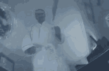 a man in a bathrobe is holding a knife in his hand .