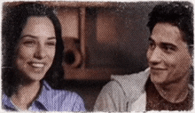 a man and a woman are smiling at each other .