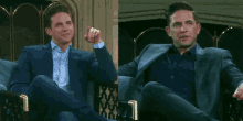 a man in a suit is sitting in a chair