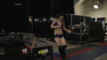 a woman in a wrestling outfit is standing in front of a sign that says #raw