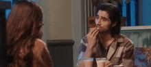a man and a woman are sitting at a table in a restaurant eating food .
