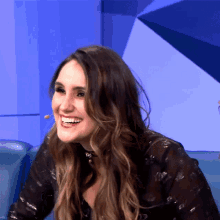 a woman with a microphone in her ear smiles