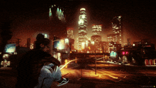 a woman sits on a sidewalk in front of a city at night with a sign that says old saloon