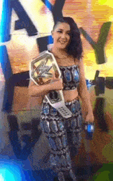 a woman in a crop top and pants is holding a wrestling championship