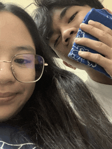 a woman wearing glasses and a man wearing a blue bandana