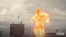 a poster for the fantastic four shows a man in flames running through a city