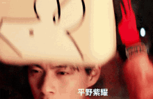 a blurry photo of a man with chinese writing on his face