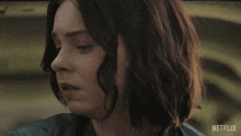 a close up of a woman 's face with a netflix logo in the background