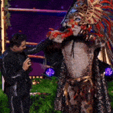 a man in a leopard costume is standing next to a man holding a microphone .