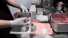 a person is putting a hamburger patty into a metal container that says made in animotica
