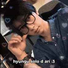 a young man wearing glasses and a denim shirt with the words hyungu solo d ari : 3 on the bottom