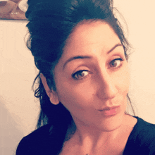 a close up of a woman 's face with a bun in her hair