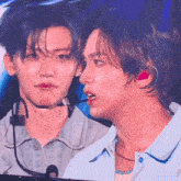 a man with a microphone in his ear is looking at another man