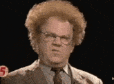 a man with curly hair and glasses is making a funny face .