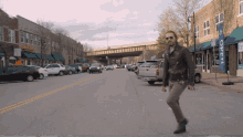 a man is walking down a street with a sign that says open