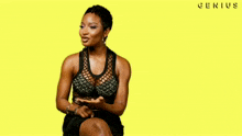 a woman in a black dress is sitting on a yellow background with the word genius written on it